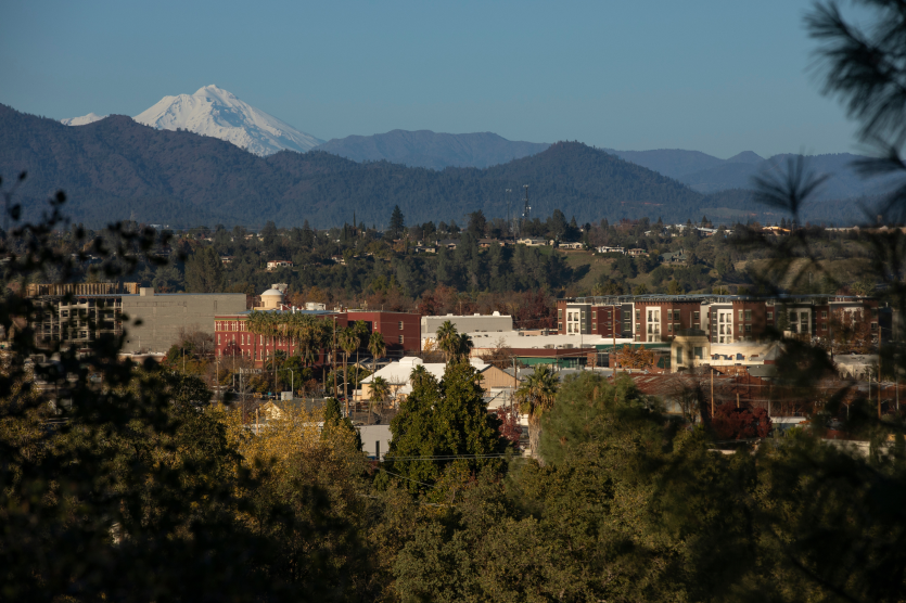 Afternoon snow covered view of the peak of Mount Shasta and the downtown skyline of Redding, California, USA. - Tailored, affordable home insurance in The Golden State