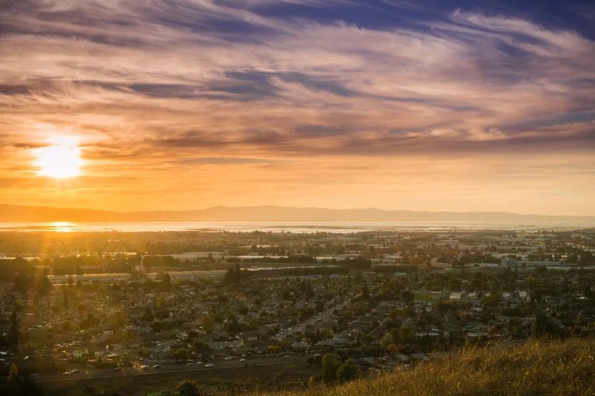 Sunset view of Hayward and Union City from Garin Dry Creek Pioneer Regional Park, east San Francisco bay shoreline and San Mateo bridge in the background, California